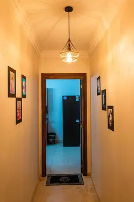 a hallway with a black door and a light at Confortable & Très Bien Noté - Vue Piscine, Proche M Avenue, Piscine, Fibre Optique, Parking in Marrakech
