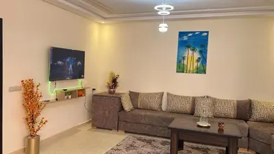 a living room with a couch and a tv at Appartement de haute standing in Marrakech
