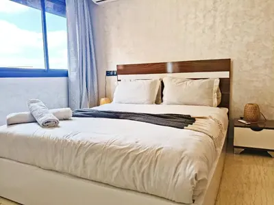 a bedroom with a large white bed with a window at Marrakech appart in Marrakech