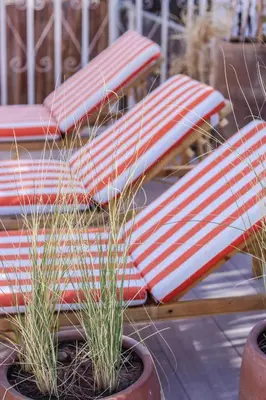 a row of red and white picnic benches with grass at Riad 10 Mandarin BOUTIQUE RIAD in Marrakech