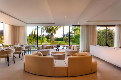 a living room with couches and tables and windows at Villa Argana moderne et luxueuse piscine chauffée in Marrakech