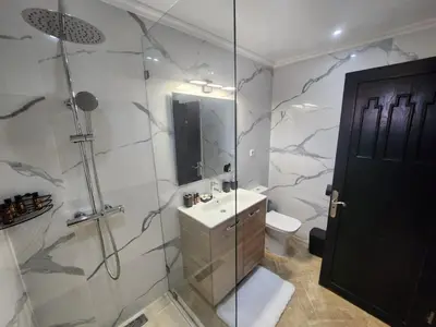 a bathroom with a shower and a sink and a toilet at Dar Atlas Lula in Marrakech