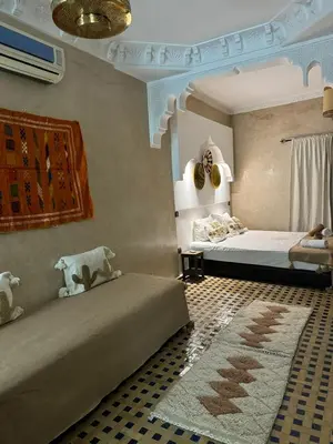 a bedroom with two beds and a rug at Riad dar serenity in Marrakech