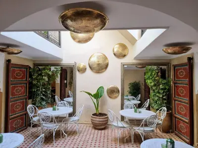 a restaurant with white tables and chairs and mirrors at Riad dar serenity in Marrakech