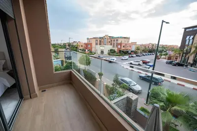 a room with a balcony with a view of a street at Jawhar Appart A3 in Marrakech