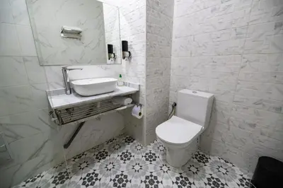 a bathroom with a white toilet and a sink at Jawhar Appart A3 in Marrakech