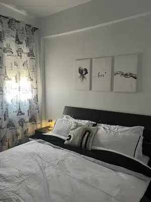 a bedroom with a large white bed with two pictures on the wall at Portes de Marrakech in Marrakech