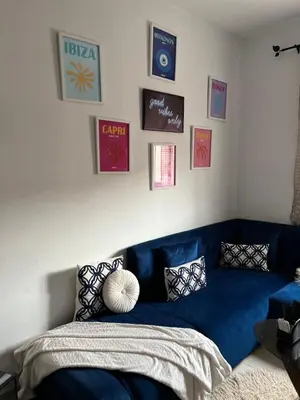 a blue couch in a room with pictures on the wall at Portes de Marrakech in Marrakech