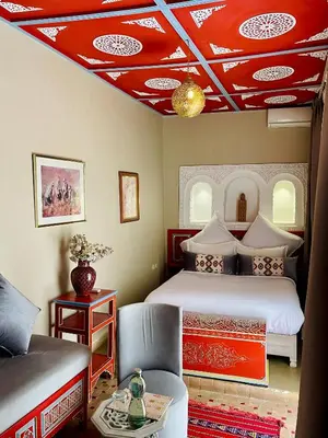 a bedroom with a bed and a red ceiling at Riad La Calèche in Marrakech