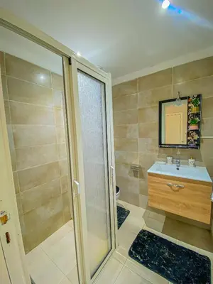 a bathroom with a shower and a sink and a mirror at Hamza Immobiler in Marrakech