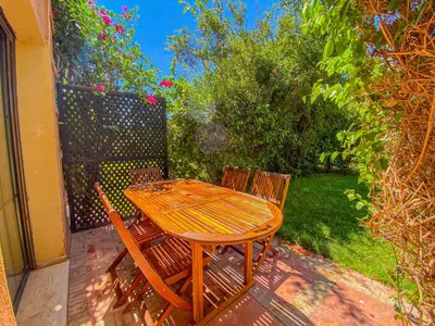 a wooden table and two chairs on a patio at Hamza immobiler in Marrakech