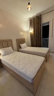two beds sitting in a room with a window at Marrakech menara in Marrakech