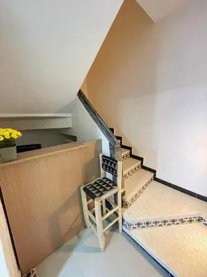 a chair sitting next to a staircase in a house at Appartement Neuf et Moderne in Marrakech