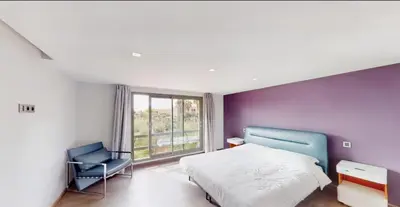 a bedroom with a bed and a chair and a window at Très Beau Duplexe avec piscine depuis la terrasse in Marrakech