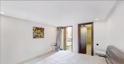 a white bedroom with a bed and a window at Très Beau Duplexe avec piscine depuis la terrasse in Marrakech