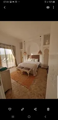a bedroom with a large bed and a large window at Villa Bohème Havre de paix, piscine chauffée,4 Suites in Marrakech