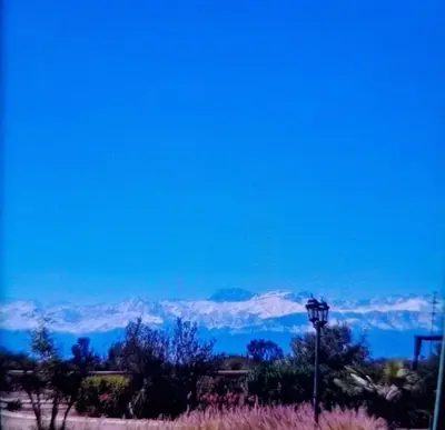 a view of snow covered mountains with a street light at Villa Bohème Havre de paix, piscine chauffée,4 Suites in Marrakech