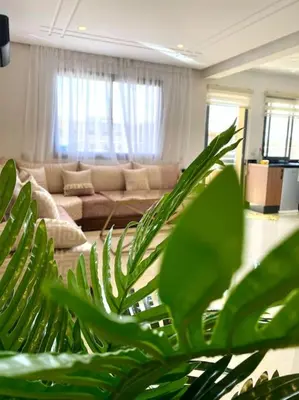 a living room with a couch and a green plant at Stylish Apartment IN Marrakech E25 in Marrakech
