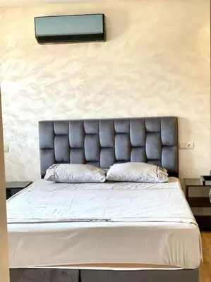 a bed with a padded headboard in a bedroom at Stylish Apartment IN Marrakech E25 in Marrakech