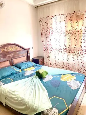 a bedroom with a bed with blue and white sheets at Apartment Comfortable Marrakech in Marrakech
