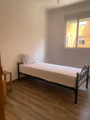 a bed in a room with a window at Issam appart in Marrakech