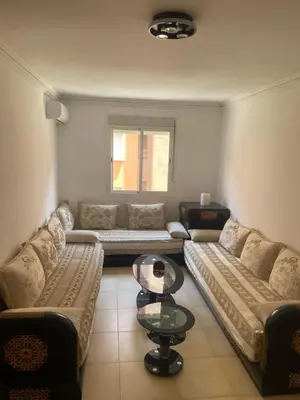 a living room with two couches and a table at Issam appart in Marrakech