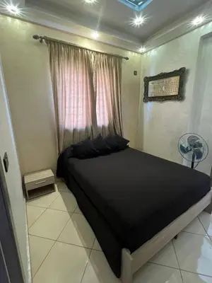a bedroom with a black bed and a window at Appartement moderne a guéliz in Marrakech