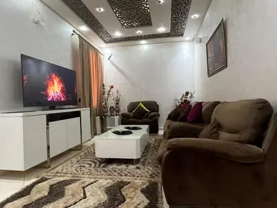 a living room with two couches and a flat screen tv at Appartement moderne a guéliz in Marrakech