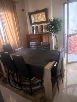 a dining room with a black table and chairs at Appartement moderne a guéliz in Marrakech