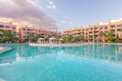 a large swimming pool in front of some apartment buildings at Appartement cosy Piscine et chill in Marrakech
