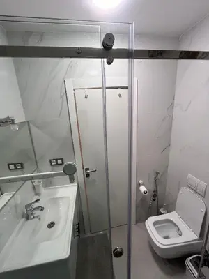 a bathroom with a shower and a toilet and a sink at Appartement Rénové avec Style et Parking surveillé in Marrakech