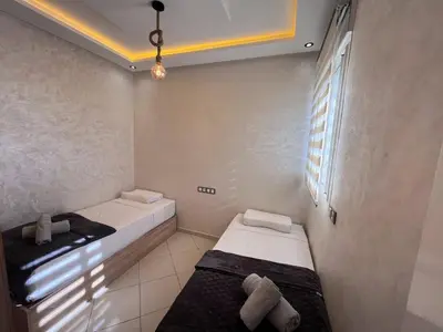 two beds in a small room with a window at Appartement Rénové avec Style et Parking surveillé in Marrakech