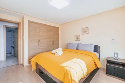 a bedroom with a large bed with a yellow blanket at Migdal Gueliz Apart Hôtel in Marrakech