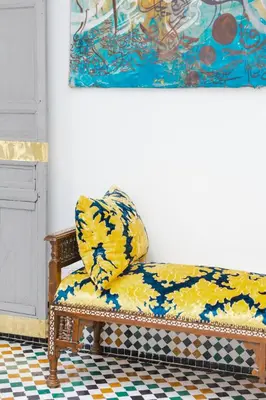 a yellow couch sitting in a room with a painting at Boutique Hotel La Maison dArts et Medicine in Marrakech