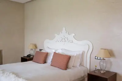 a bedroom with a white bed with pillows and two lamps at Villa Tamari in Marrakech