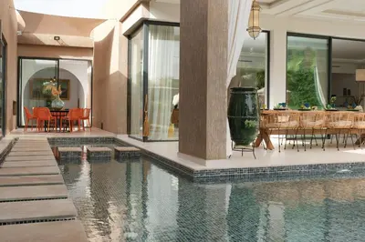 a house with a swimming pool and a dining room at Villa Netumia in Marrakech