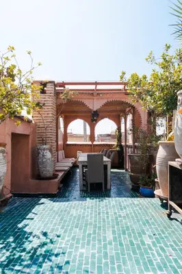 an outdoor patio with a table and a pool at Boutique Hotel Riad Almoulouk in Marrakech