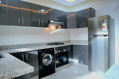 a kitchen with a washer and a stainless steel refrigerator at The Elite suites in Marrakech
