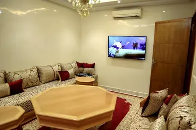 a living room with a couch and a tv on the wall at Majestic luxe appartment in Marrakech