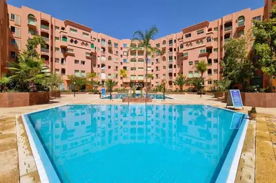 a large swimming pool in front of a building at Best location new appart hivernag Pool FreeParking in Marrakech
