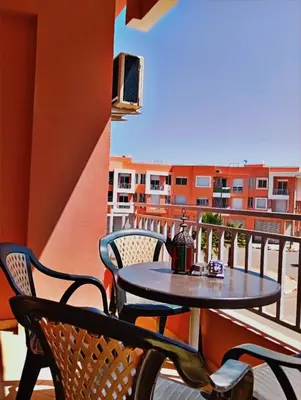 a table and chairs on the balcony of a apartment at Appartement calme et spacieux in Marrakech