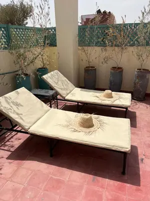 two beds with hats on them on a patio at Riad Nafora in Marrakech