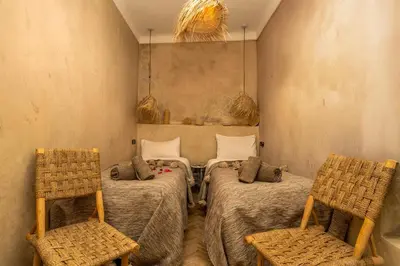 a room with two beds and two chairs at Riad Nafora in Marrakech