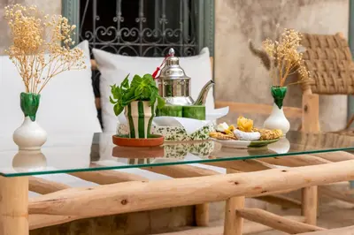 a glass coffee table with a tray of food on it at Riad Nafora in Marrakech