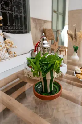a table with a tea pot and a plant on it at Riad Nafora in Marrakech
