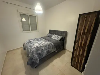 a bedroom with a bed and a window at Joli appartement nouveau Rez-de-chaussée in Marrakech