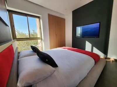 a bedroom with a large white bed and a window at Appartement Central, vue Piscine-Golf, Lac et Montagne de L'atlas in Marrakech