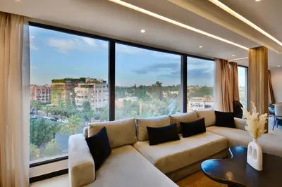 a living room with a couch and large windows at Hevernage penthouse in Marrakech