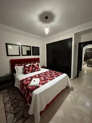 a bedroom with a large bed with a laptop on it at Appart de luxe a gueliz a bon prix in Marrakech