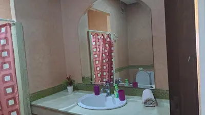 a bathroom with a sink and a large mirror at Appartement au cœur de centre ville in Marrakech